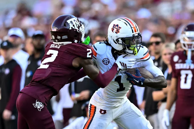 Sep 27, 2025; College Station, Texas, USA; Auburn Tigers wide receiver Eric Singleton Jr. (1) runs the ball during the third quarter as Texas A & M Aggies cornerback Dezz Ricks (2) defends at Kyle Field. Mandatory Credit: Maria Lysaker-Imagn Images