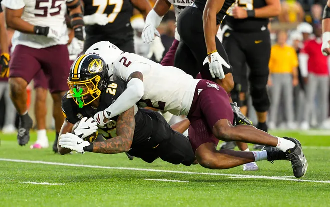 Nov 8, 2025; Columbia, Missouri, USA; Missouri Tigers running back Jamal Roberts (20) dives forward against Texas A & M Aggies cornerback Dezz Ricks (2) during the second half at Faurot Field at Memorial Stadium. Mandatory Credit: Jay Biggerstaff-Imagn Images