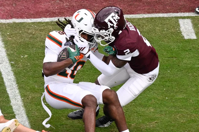 Dec 20, 2025; College Station, TX, USA; Texas A & M Aggies cornerback Dezz Ricks (2) brings down Miami Hurricanes wide receiver Malachi Toney (10) during first quarter of the first round game of the CFP National Playoff at Kyle Field. Mandatory Credit: Jerome Miron-Imagn Images
