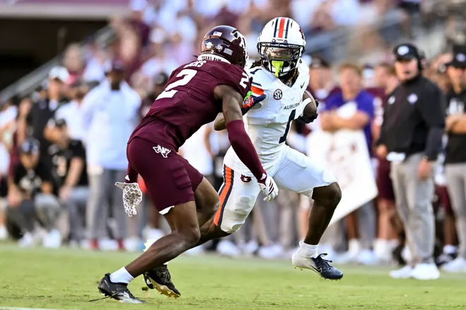 Sep 27, 2025; College Station, Texas, USA; Auburn Tigers wide receiver Eric Singleton Jr. (1) runs the ball as Texas A & M Aggies cornerback Dezz Ricks (2) defends during the second half at Kyle Field. Mandatory Credit: Maria Lysaker-Imagn Images