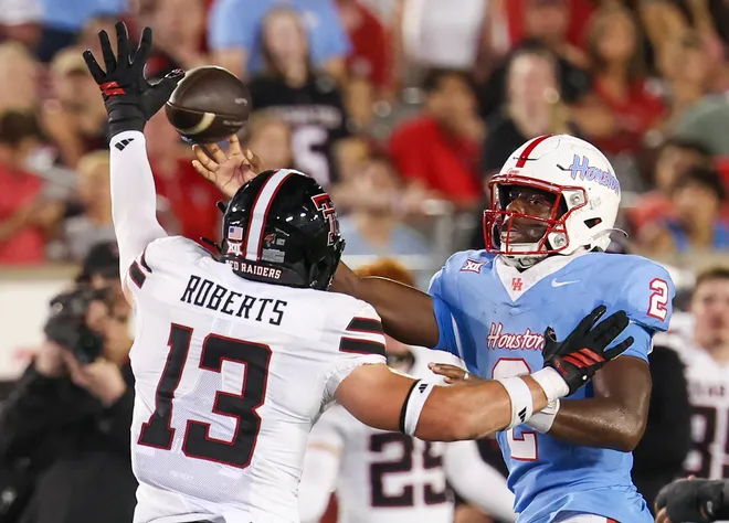 Oct 4, 2025; Houston, Texas, USA; Houston Cougars quarterback Zeon Chriss (2) passes against Texas Tech Red Raiders linebacker Ben Roberts (13) in the second half  at TDECU Stadium. Mandatory Credit: Thomas Shea-Imagn Images