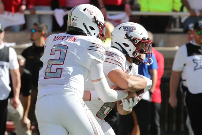 Nov 8, 2025; Lubbock, Texas, USA; Texas Tech Red Raiders quarterback Behren Morton (2) hands the ball to running back Cameron Dickey (8) in the first half against the Brigham Young Cougars at Jones AT & T Stadium. Mandatory Credit: Michael C. Johnson-Imagn Images