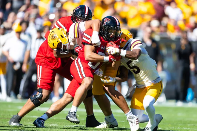 Oct 18, 2025; Tempe, Arizona, USA; Texas Tech Red Raiders running back Cameron Dickey (center) is tackled by the Arizona State Sun Devils defense in the first half at Mountain America Stadium. Mandatory Credit: Mark J. Rebilas-Imagn Images
