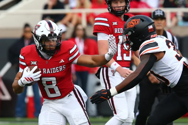Oct 25, 2025; Lubbock, Texas, USA; Texas Tech Red Raiders running back Cameron Dickey (8) stiff arms Oklahoma State Cowboys defensive back Trip White (30) in the first half at Jones AT & T Stadium. Mandatory Credit: Michael C. Johnson-Imagn Images