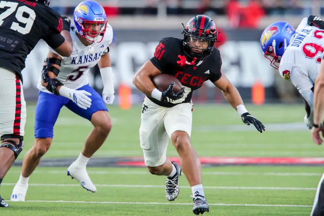 Oct 11, 2025; Lubbock, Texas, USA; Texas Tech Red Raiders running Cameron Dickey (9) rushes against Kansas Jayhawks defensive end Dean Miller (5) in the first half at Jones AT & T Stadium. Mandatory Credit: Michael C. Johnson-Imagn Images