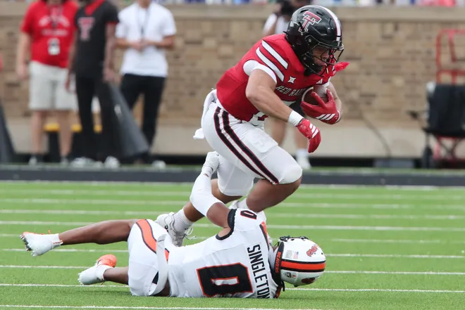 Sep 13, 2025; Lubbock, Texas, USA; Oregon State Beavers defensive back Koby Singleton (0) tackles Texas Tech Red Raiders running back Cameron Dickey (8) in the first half at Jones AT & T Stadium. Mandatory Credit: Michael C. Johnson-Imagn Images