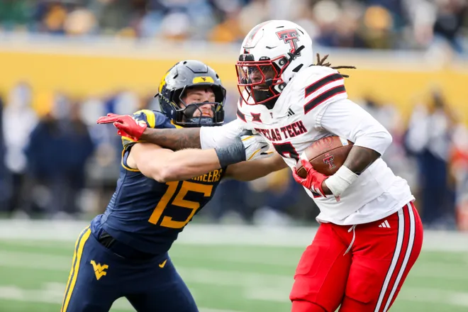 Nov 29, 2025; Morgantown, West Virginia, USA; Texas Tech Red Raiders tight end Terrance Carter Jr. (7) makes a catch and is tackled by West Virginia Mountaineers linebacker Ben Cutter (15) during the second quarter at Milan Puskar Stadium. Mandatory Credit: Ben Queen-Imagn Images