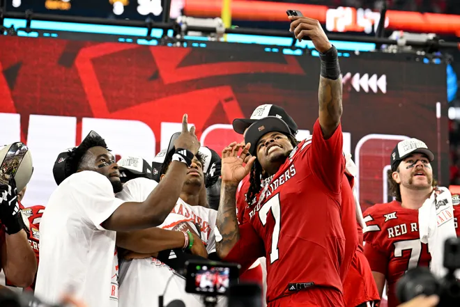 Dec 6, 2025; Arlington, TX, USA; Texas Tech Red Raiders tight end Terrance Carter Jr. (7) celebrates with his teammates and the trophy after the win over the BYU Cougars at AT & T Stadium. Mandatory Credit: Jerome Miron-Imagn Images