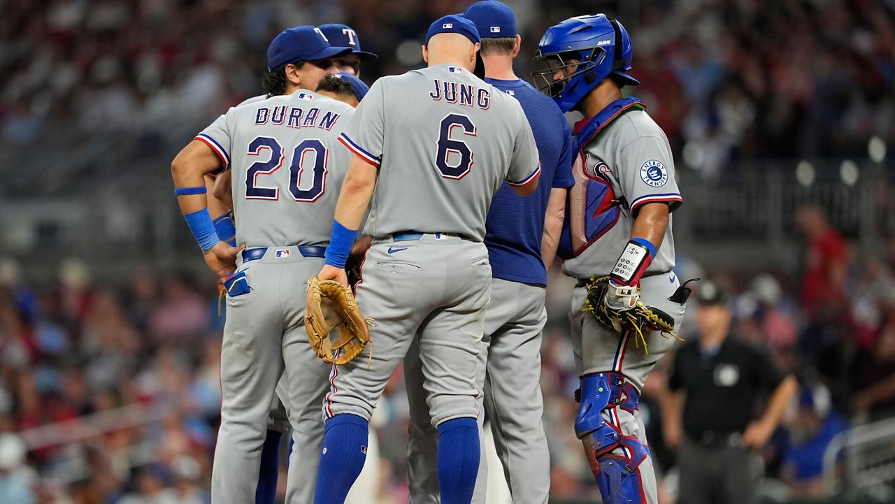 The Texas Rangers speak with pitcher Emiliano Teodo on the mound in the fifth inning of a baseball game against the Atlanta Braves, Friday, July 17, 2026, in Atlanta. (AP Photo/Mike Stewart)