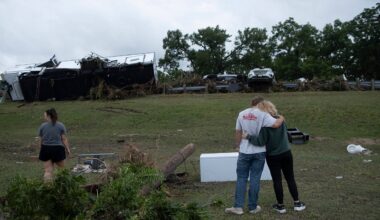 Ryder Wade is comforted by his mother Crystal Wade as they assess flood debris and damage scattered across the Buckhorn Lake Resort RV Park following floods along West Goat Creek near the Guadalupe River on Friday, July 17, 2026, in Kerrville, Texas. (AP Photo/Joel Angel Juarez)