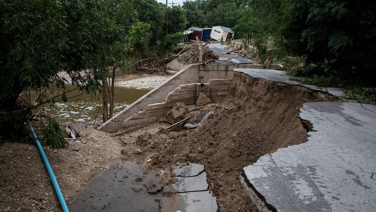 A partially-collapsed bridge crossing Goat Creek is damaged following floods near the Guadalupe River on Friday, July 17, 2026, in Kerrville, Texas. (AP Photo/Joel Angel Juarez)