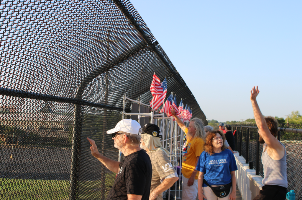The group of Arlington protestors wave at commuters from the bridge.