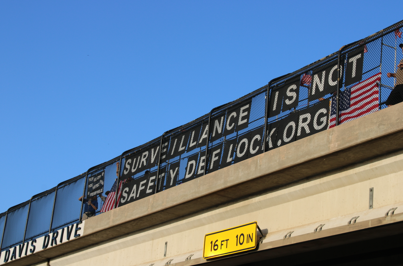 Activists display a sign reading "Surveillance is not safety" in Arlington.