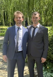image of two men standing next to each other in suits