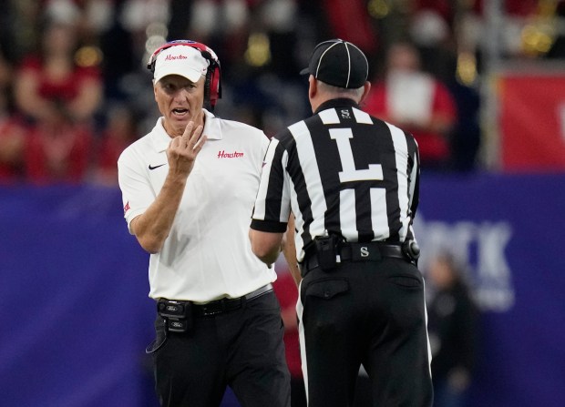 Houston head coach Willie Fritz, left, talks with referee Jim Wharrie, right, during the first half of the Kinder's Texas Bowl NCAA football game against LSU, Saturday, Dec. 27, 2025, in Houston. (AP Photo/Karen Warren)