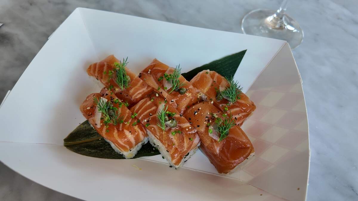 Salmon sushi made by Chef Hiro was pressed into a mold and then topped with onion, capers and dill.