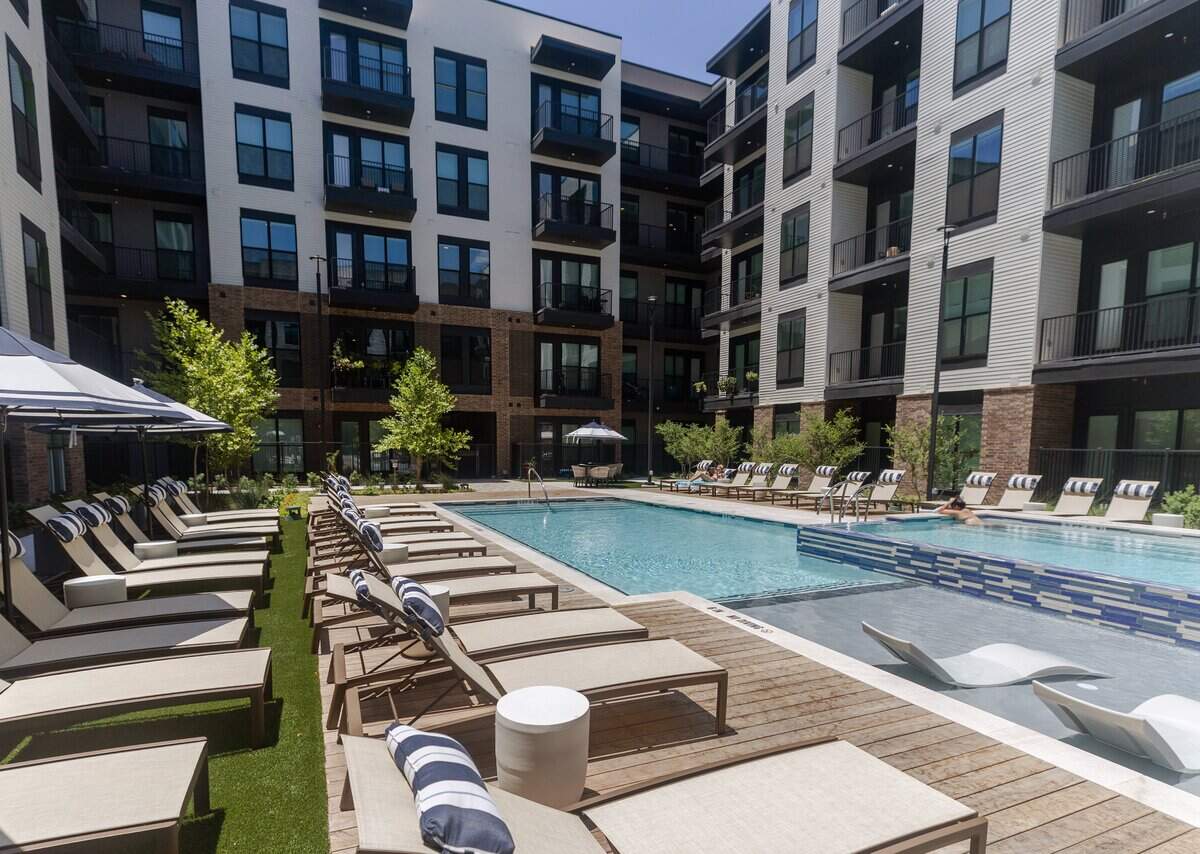 Residents sun bathe and swim in a pool at The Vickery apartments on Vickery Boulevard in Fort Worth on July 10, 2026.