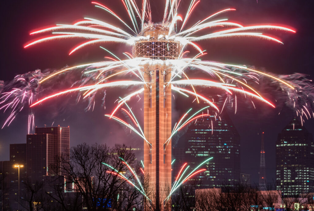 Image shows fireworks going off around the Reunion Tower in Dallas.