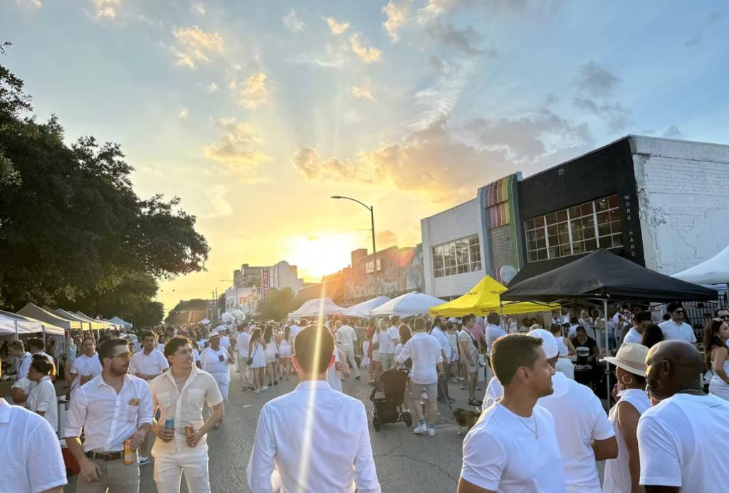 Image shows a huge crowd of people on West 19th Street in The Heights for White Linen Night.