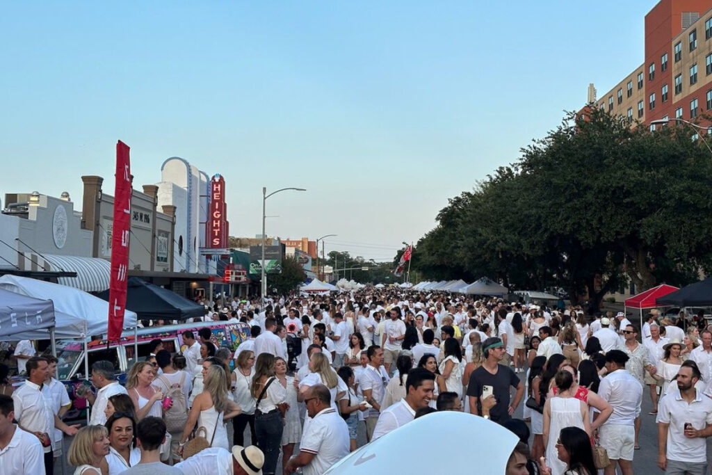 Image shows a crowd of people dressed in white for White Linen Night in Houston on West 19th Street in The Heights.