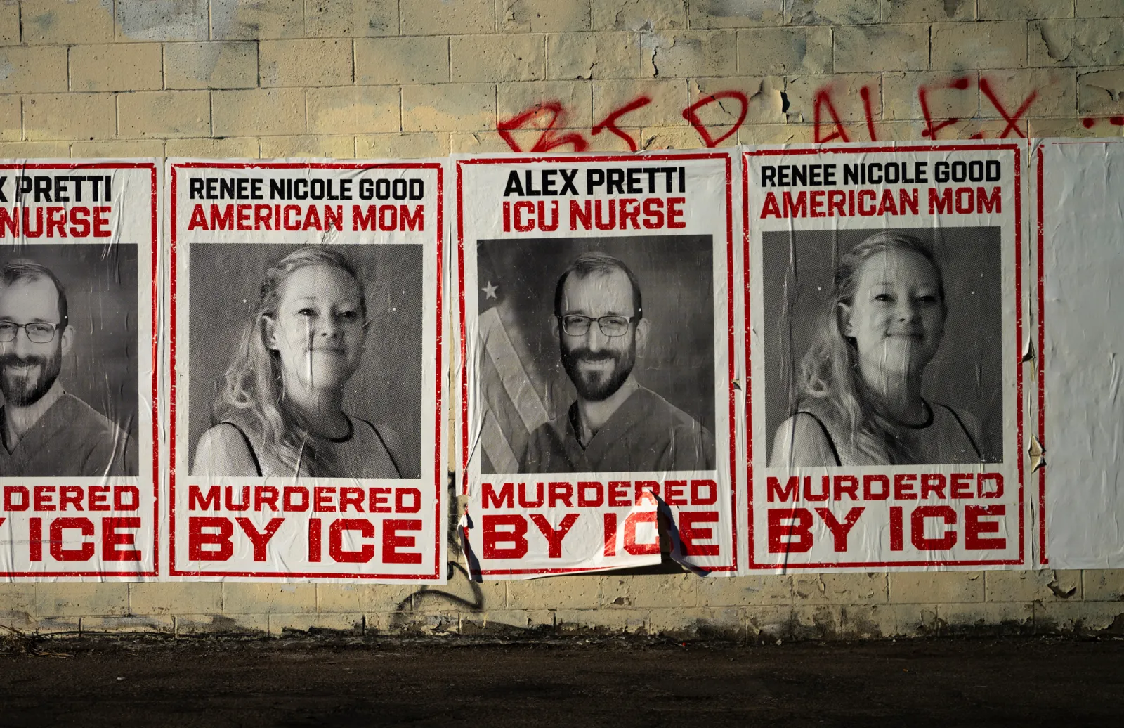 Signs memorializing Renee Good and Alex Pretti are seen pasted on the wall of a building in Minneapolis on February 12, 2026.