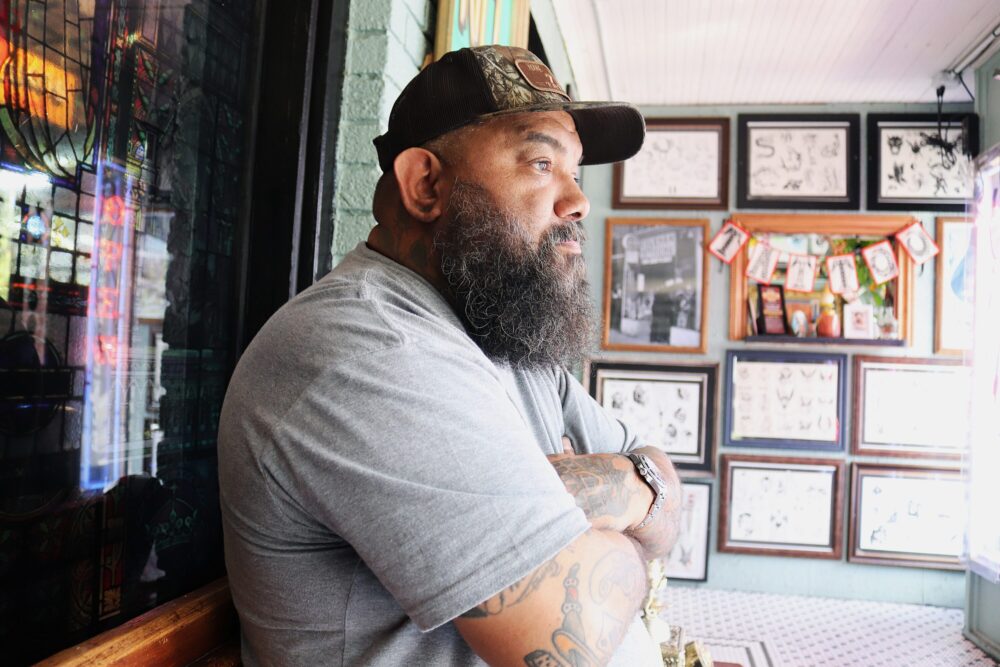 Bianca Seward/Houston Public Media 713 Tattoo owner Homer Saenz first met Tim Walker 20 years ago. He commissioned his iconic storefront neon signs from Walker.