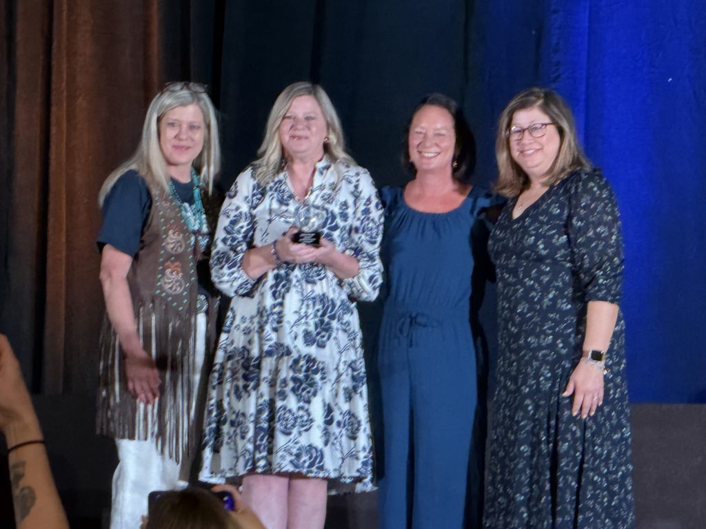 Superintendent on stage holding award