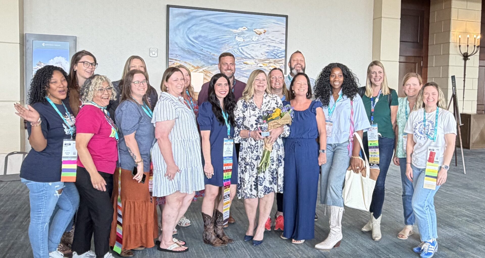 Superintendent Branum surrounded by several PTA leaders posing with award and flowers