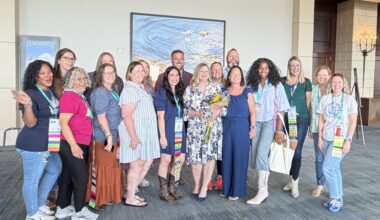 Superintendent Branum surrounded by several PTA leaders posing with award and flowers