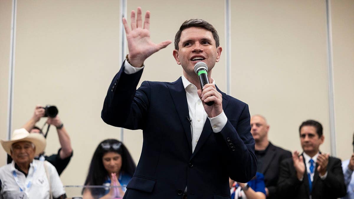James Talarico speaks while holding a microphone