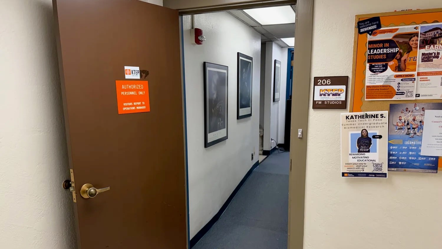 An open door leads into the KTEP-FM studios at the University of Texas at El Paso. A sign identifies the entrance as “206 KTEP FM Studios,” while campus flyers hang on a bulletin board outside the studio hallway.
