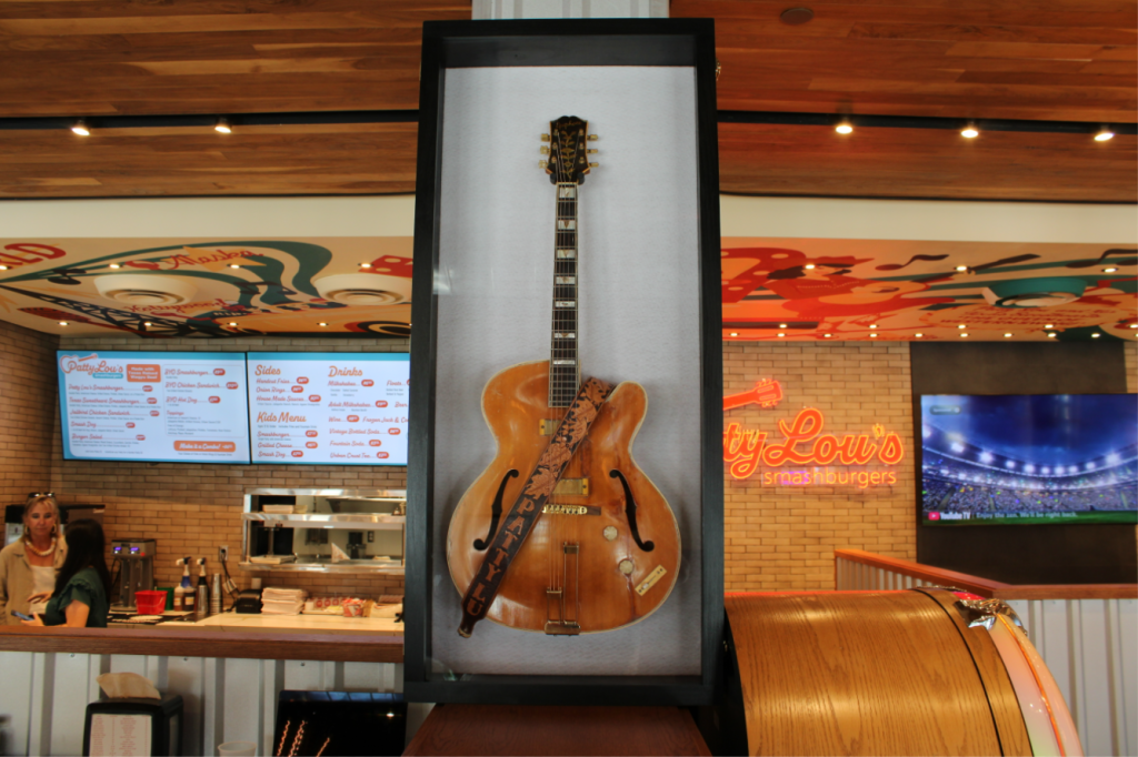 Patty Lou's performance guitar sits in a display case above a jukebox.