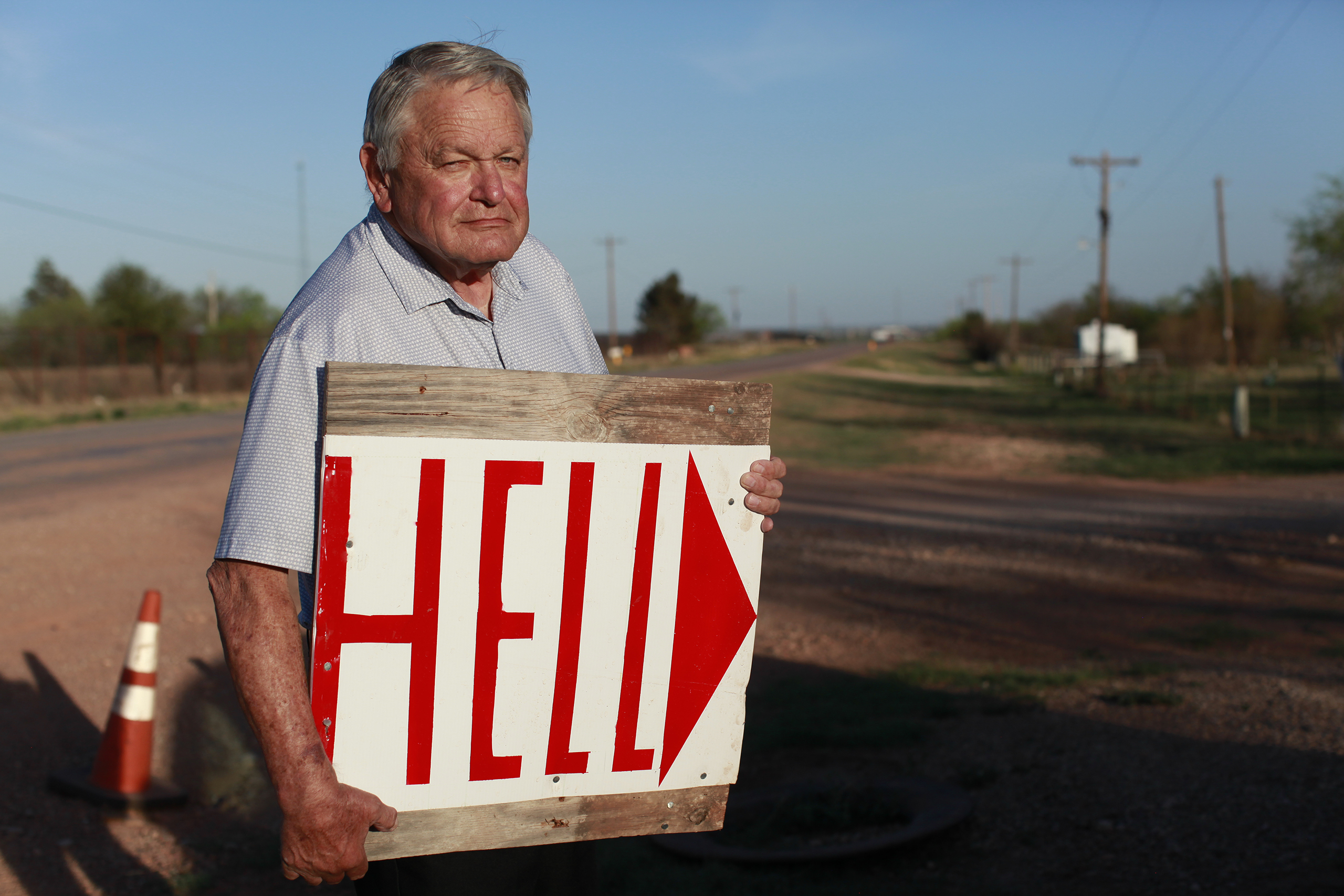 Paul Daniel, 81, lives directly beside OpenAI’s “Stargate” data center. Like his neighbor, Omaira Garcia, Daniel says he was never informed of the project until it was too late to leave. He made this sign and placed it on the road leading to Stargate’s entrance. “It just kind of ruined our area,” Daniel says.