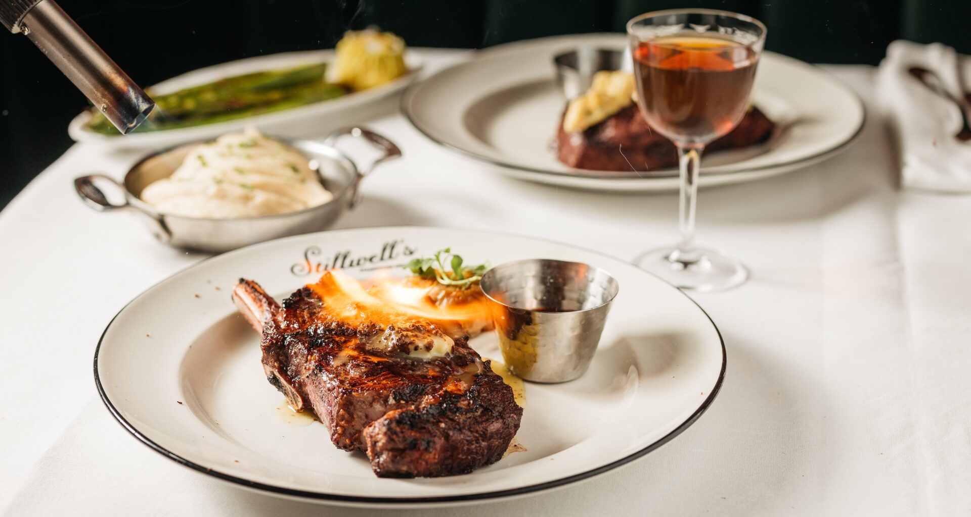 a steak being torhced on a plate at Stillwell's