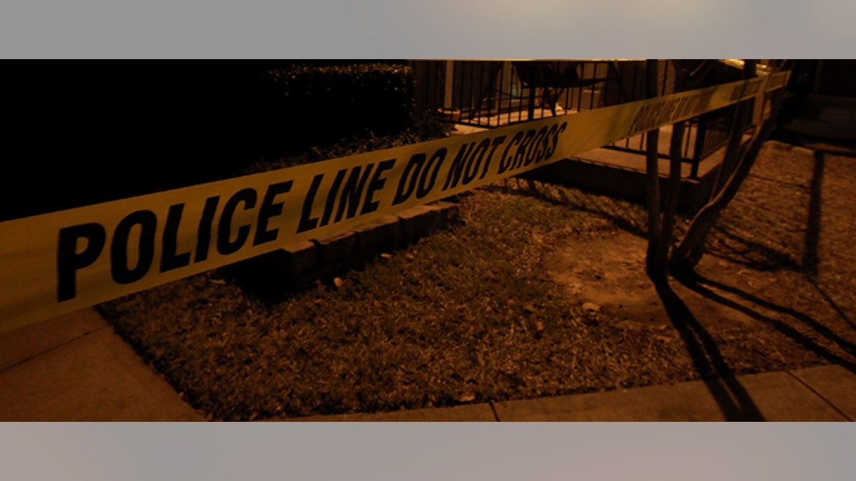 GRAPEVINE, TX - DECEMBER 25: Police line tape surrounds an apartment building where seven people were found dead at Lincoln Vineyard Apartment Homes on December 25, 2011 in Grapevine, Texas. (Photo by Ronald Martinez/Getty Images)