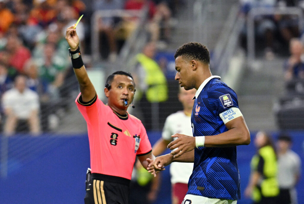 July 14, 2026; Arlington, Texas, U.S.; France's Kylian Mbappe is shown a yellow card by referee Ivan Barton. Mandatory Credit: Jerome Miron-Imagn Images