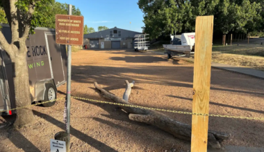 Fence posts and a sign saying "Property of White Rock Rowing" stand outside White Rock Boathouse.