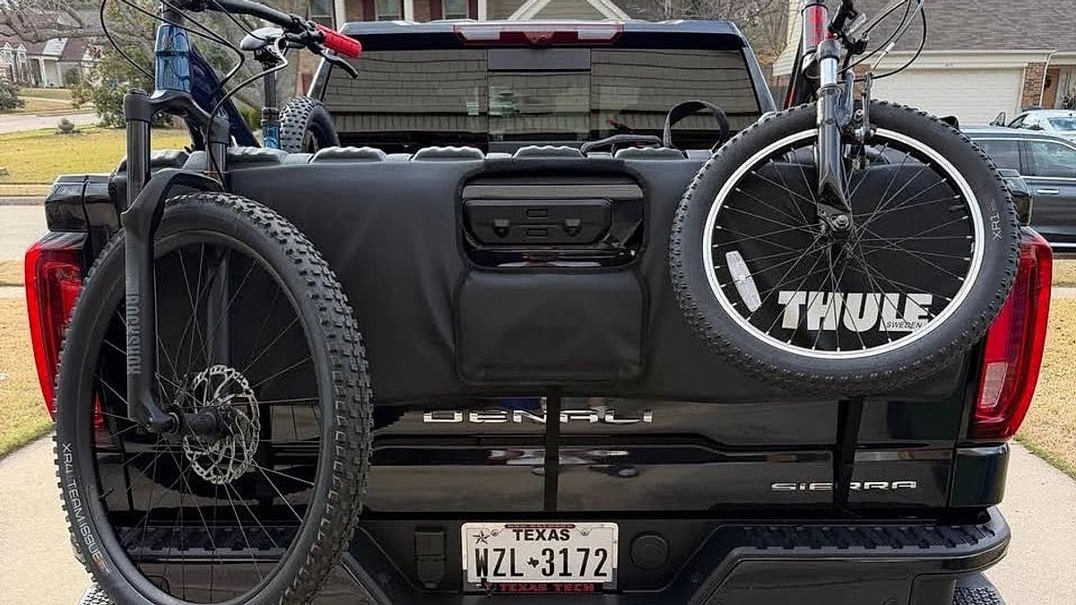 A black 2026 GMC Sierra Denali parked in an Arlington, Texas driveway with a bike rack on the back