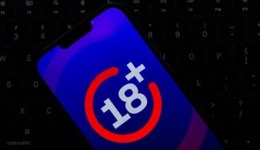 Age verification of 18+ is on a phone screen. The phone rests on a laptop keyboard.