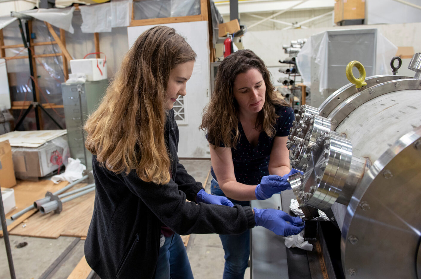 two people working on a cyclotron instrument