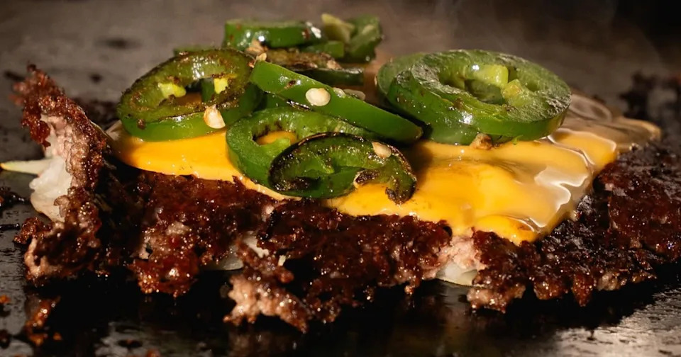 Close up of a smash burger patty at ZOJAH Burger in San Antonio with cheese and jalapenos