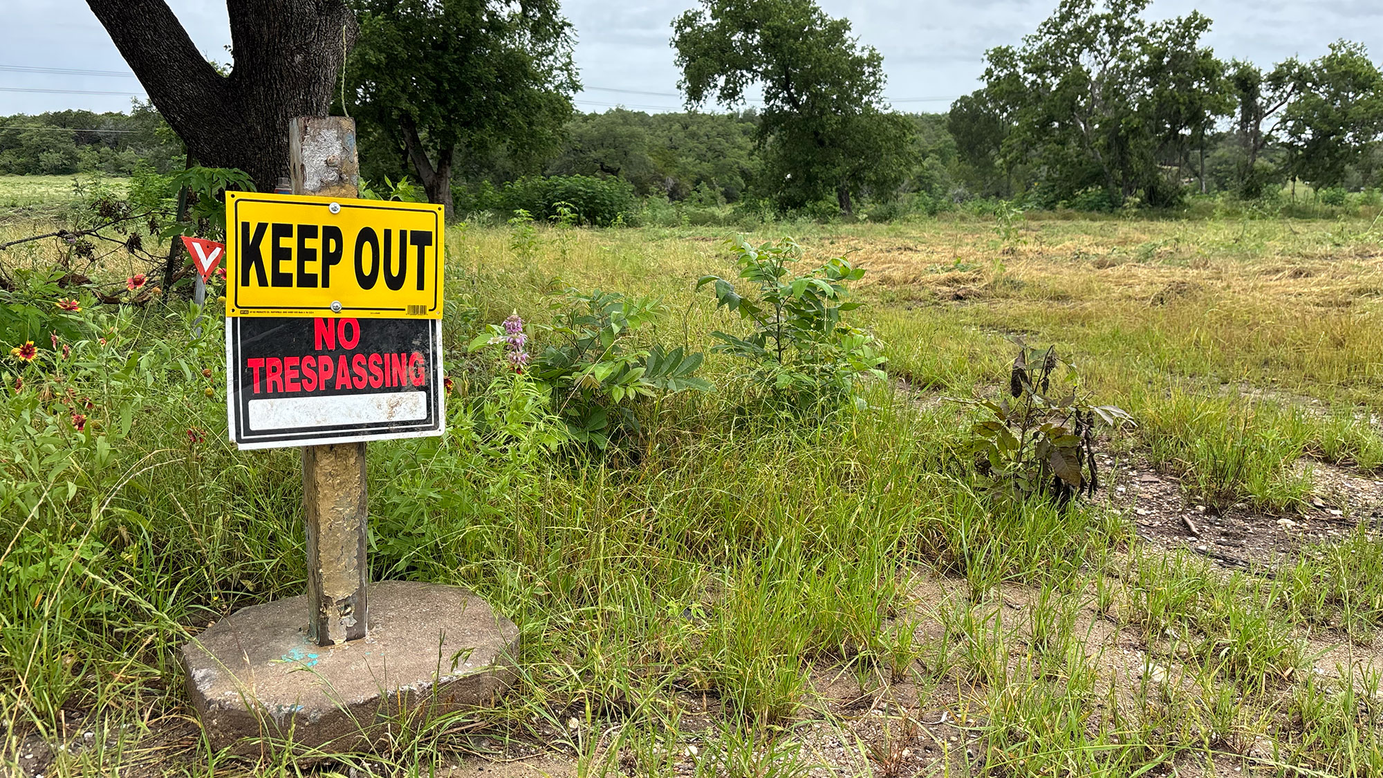 A keep out no trespassign sign on an empty lot in Texas after flooding