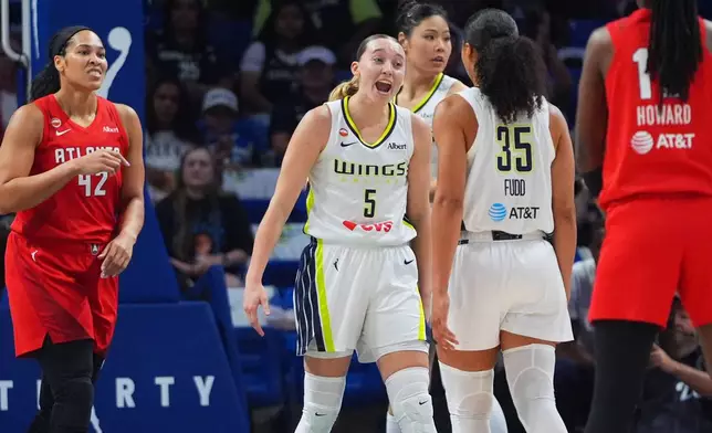 Dallas Wings guard Paige Bueckers (5) reacts with teammate guard Azzi Fudd (35) as Atlanta Dream forward Brionna Jones (42) looks on during the first half of a WNBA basketball game in Arlington, Texas, Wednesday, July 29, 2026. (AP Photo/LM Otero)
