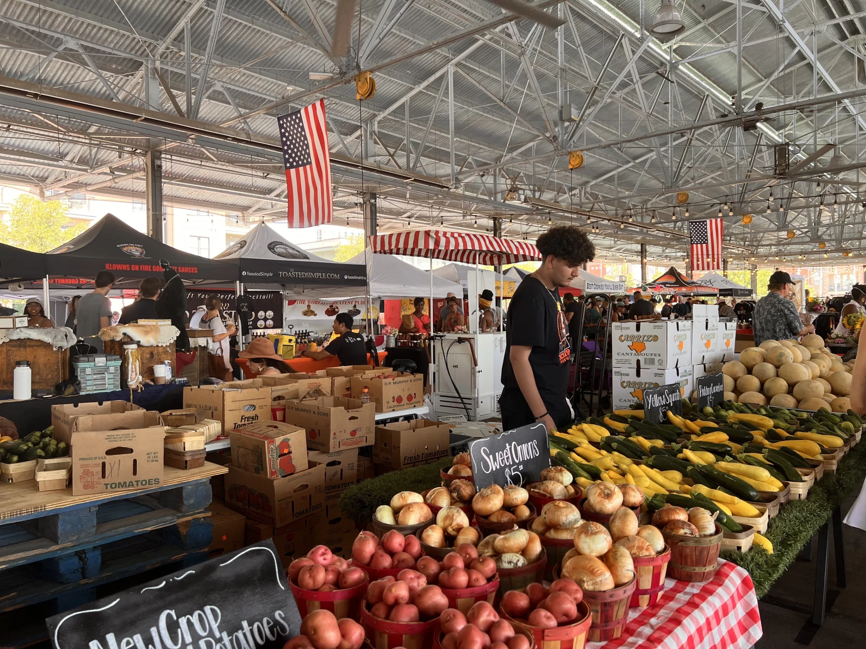 A local North Texas producer sells at the Dallas Farmers Market on a Saturday afternoon in July. Stalls at the market are under shade to protect vendors and buyers from the blinding Texas heat.