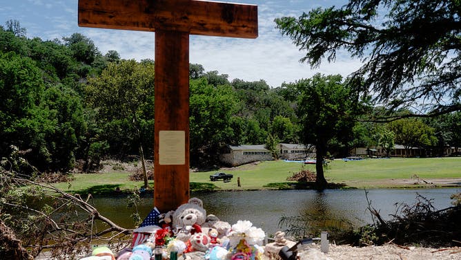 CENTER POINT, TEXAS - JULY 18: A 10-foot cross is seen along the banks of the Guadalupe River in front of Camp Mystic on July 18, 2025 in Hunt, Texas.