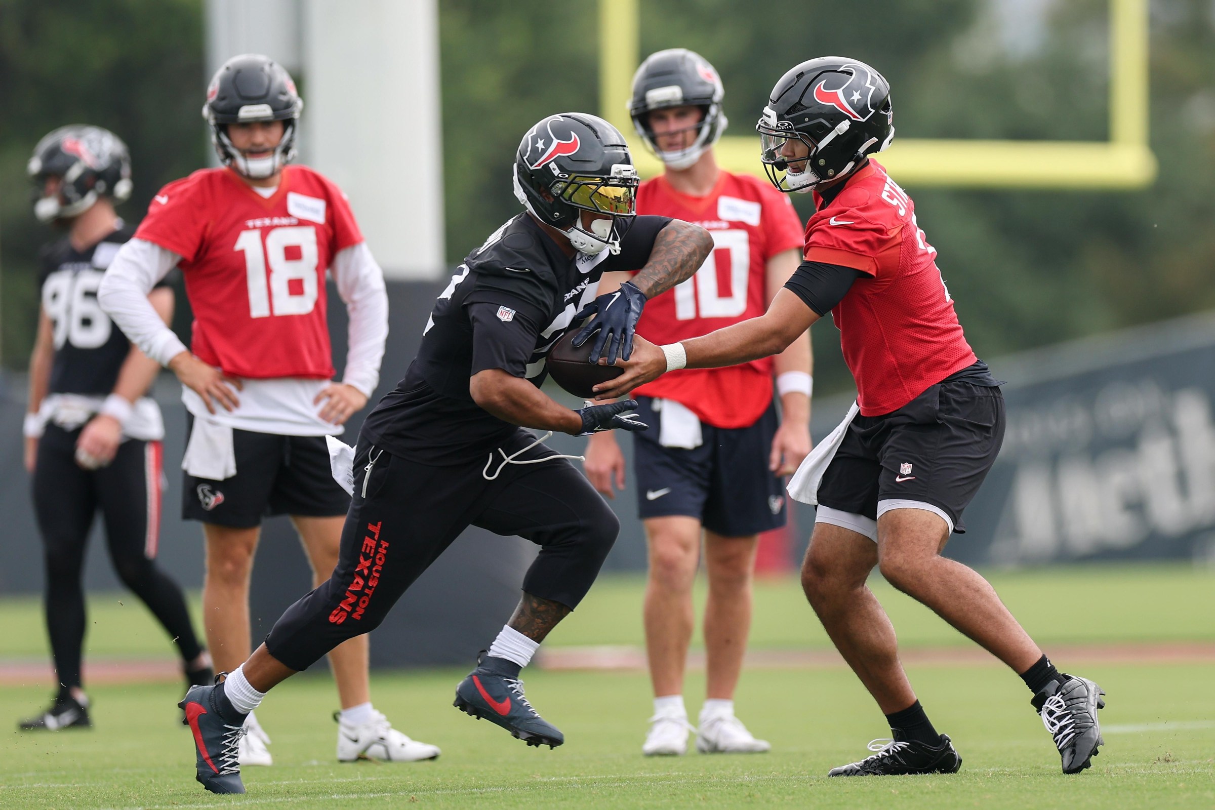 HOUSTON, TEXAS - JUNE 04: C.J. Stroud #7 of the Houston Texans hands off to David Montgomery #32 during OTA Offseason Workouts at Houston Methodist Training Center on June 04, 2026 in Houston, Texas. (Photo by Tim Warner/Getty Images)
