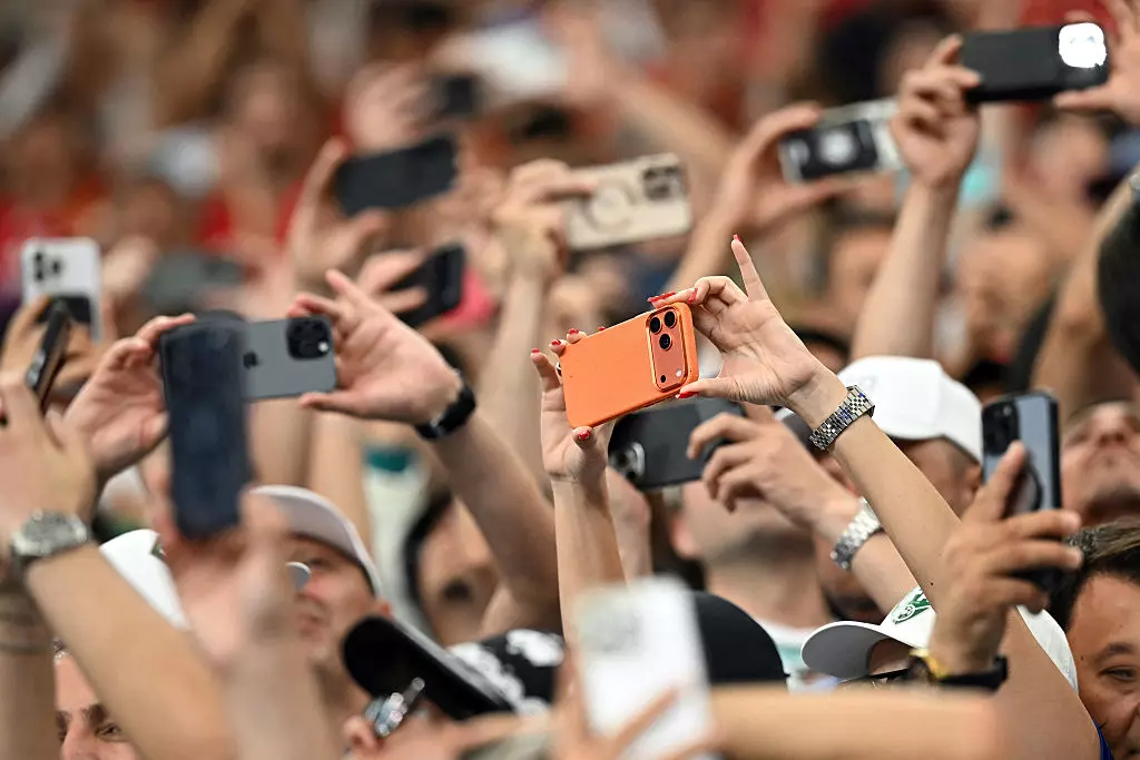 Spectators take photos with their smartphones during a World Cup match at the Houston Stadium in Houston on June 23. The Supreme Court is allowing Texas to enforce a law that limits minors' access to app stores on mobile devices while lawsuits continue in the lower courts.