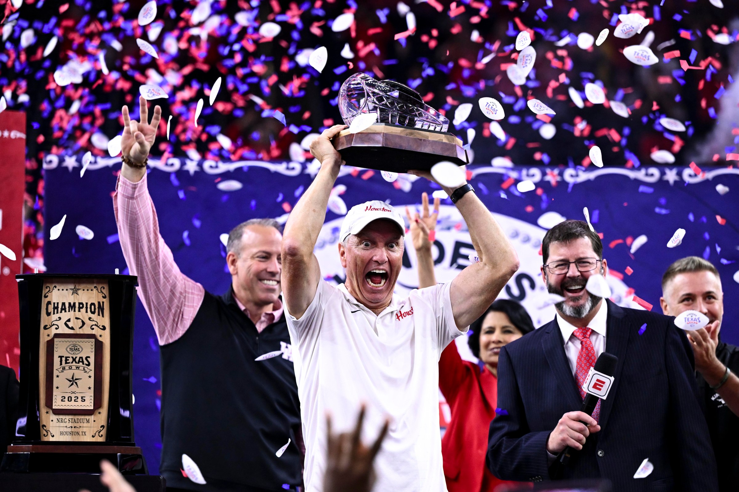 Dec 27, 2025; Houston, TX, USA; Houston Cougars head coach Willie Fritz hoists the champions trophy after the win over Louisiana State Tigers at NRG Stadium. Mandatory Credit: Maria Lysaker-Imagn Images