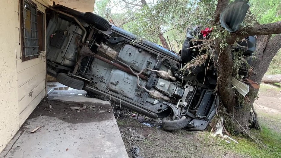 Flipped vehicles rest against a building after flooding in Central Texas in July 2026.