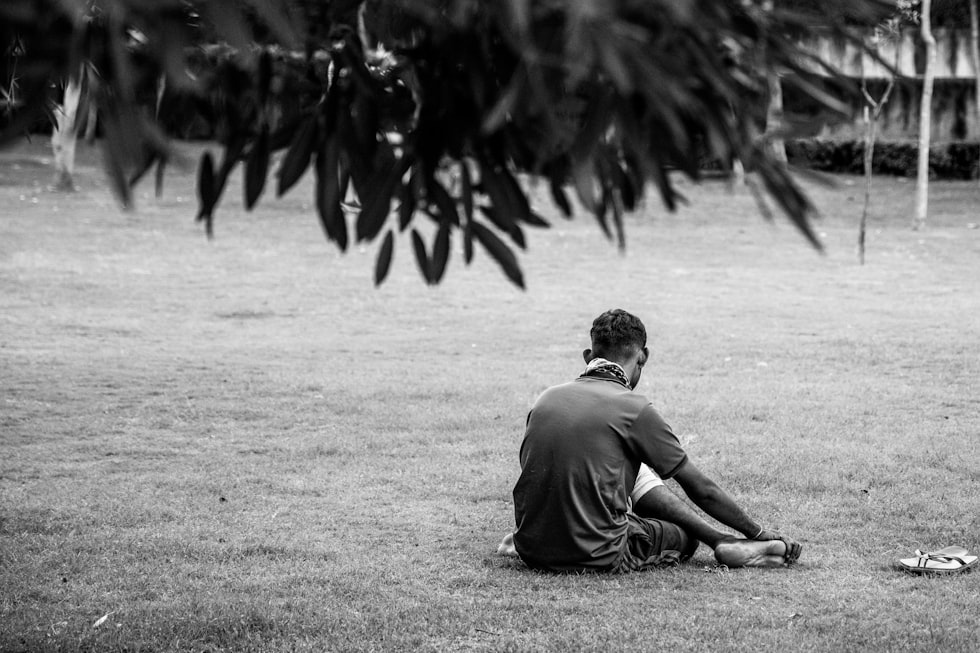 man in gray t-shirt sitting on ground